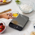 Etekcity Luminary™ Kitchen Scale on a counter with bowl of ingredients around it