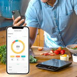 A person viewing nutrition facts on the VeSync app next to the Etekcity Luminary™ Smart Nutrition Scale