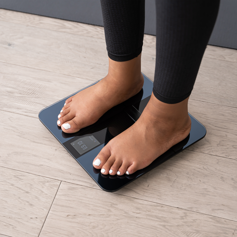 Feet standing on the Etekcity HR Smart Fitness Scale 